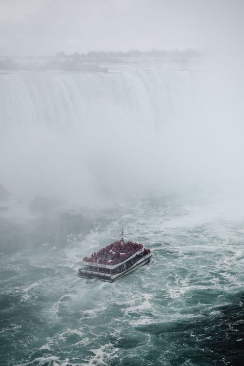 Free A dramatic view of a tourist boat at Niagara Falls, Ontario, Canada, showcasing the powerful waterfalls. Stock Photo