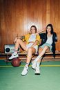 3 Women Sitting on Basketball Court