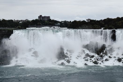 Breathtaking view of Niagara Falls with mist on a cloudy day. Iconic natural wonder in Ontario, Canada.