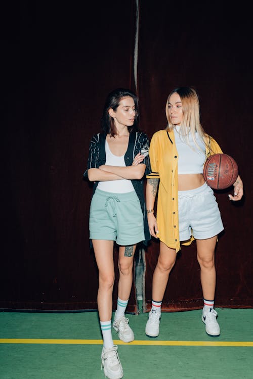 Women Standing Side by Side with a Basketball