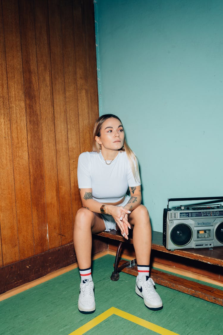 Woman Listening To The Radio While Sitting On A Bench