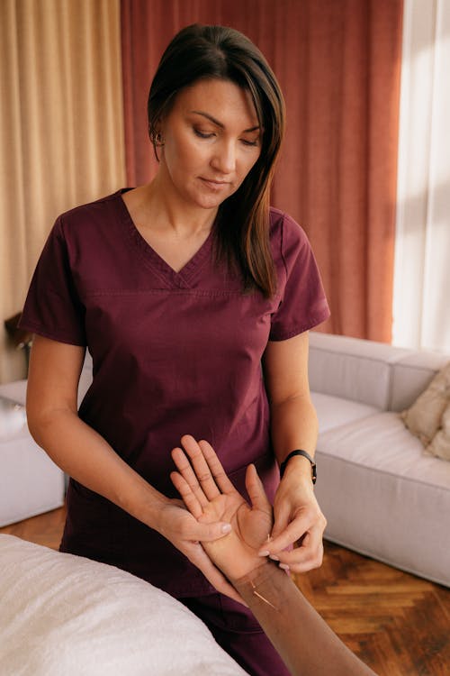 Free Acupuncturist Putting Needles on the Hand of a Patient Stock Photo