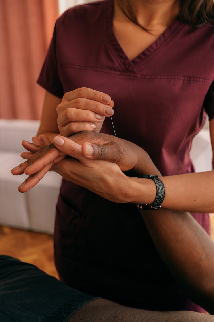 Person Wearing Scrub Suit Putting Needle On A Hand