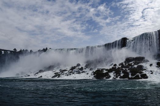 Majestic view of Niagara Falls captured from below, showcasing water cascade and mist.