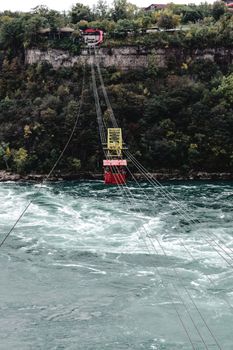 Aerial cable car traversing the Niagara Gorge over the whirlpool, surrounded by lush forest.