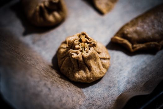 Close-up of traditional steamed dumplings on baking paper, highlighting their texture and rich filling.