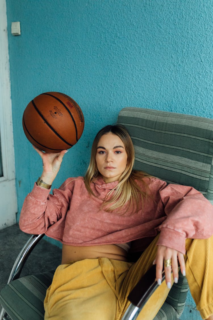 Woman Sitting On A Chair Holding Basketball