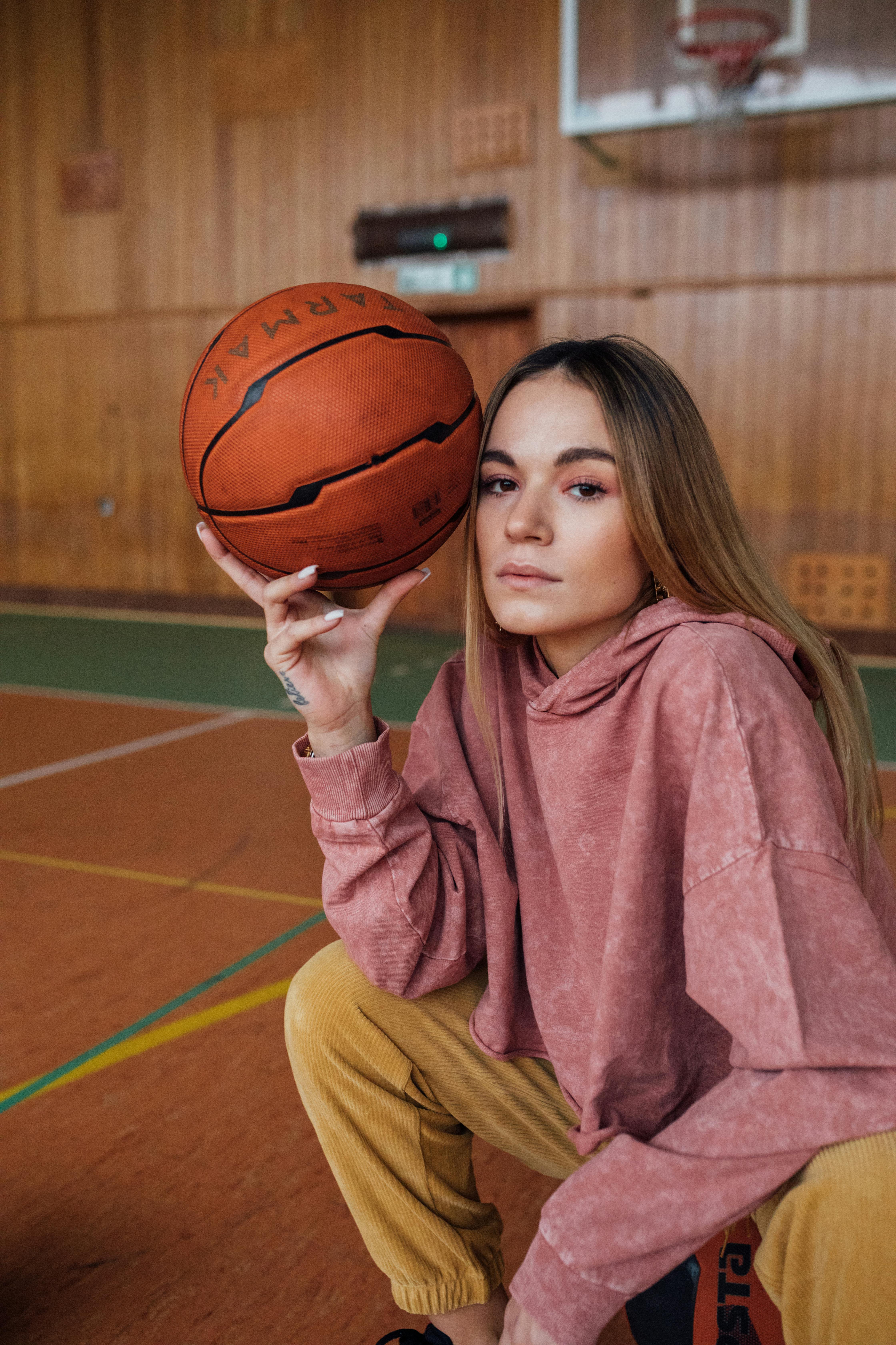 girl in red hoodie holding basketball