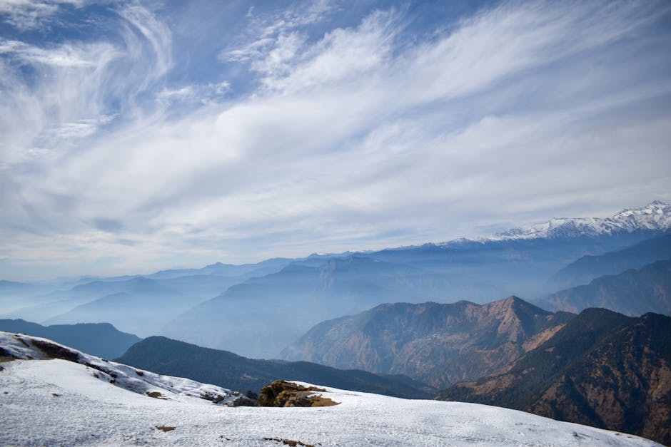 Breathtaking winter landscape with snow-capped mountains under a cloudy sky.