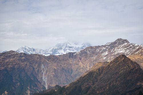 Free Explore the stunning view of snow-capped peaks and rugged landscapes under a dramatic cloudy sky, perfect for nature enthusiasts. Stock Photo