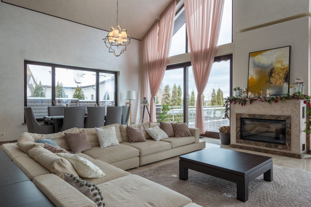 A sunlit, elegant living space in a beautiful stay, soft drapes and warm light