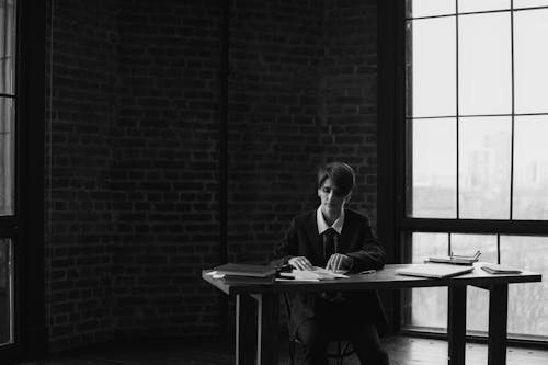 Woman Sitting by Table with Books