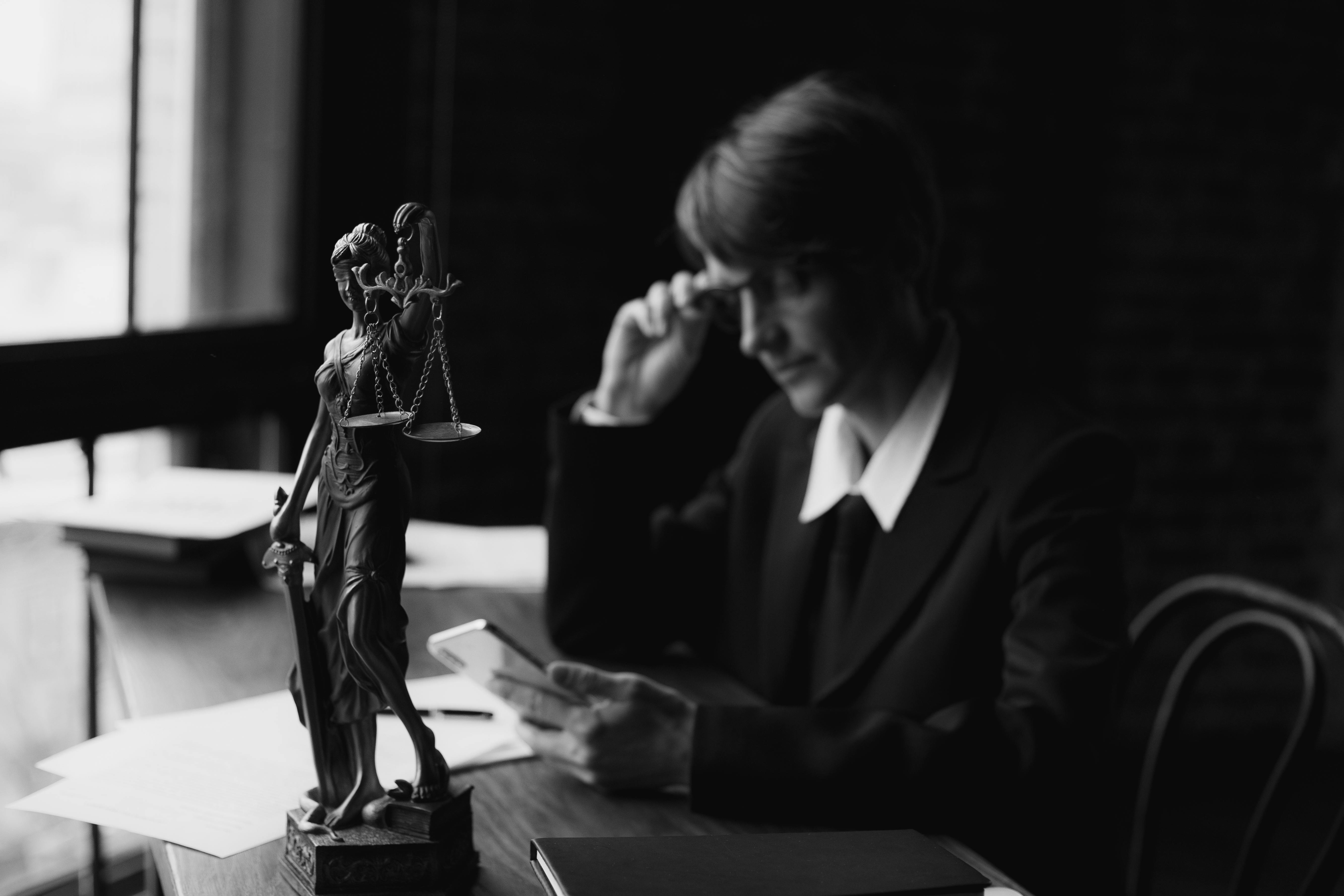 grayscale photo of a lawyer using a mobile phone