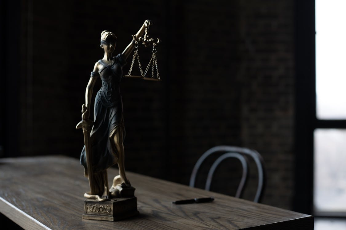 Free A Figurine of the Lady Justice on a Table Stock Photo