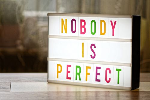 Free Illuminated lightbox displaying the motivational slogan 'Nobody is Perfect'. Stock Photo