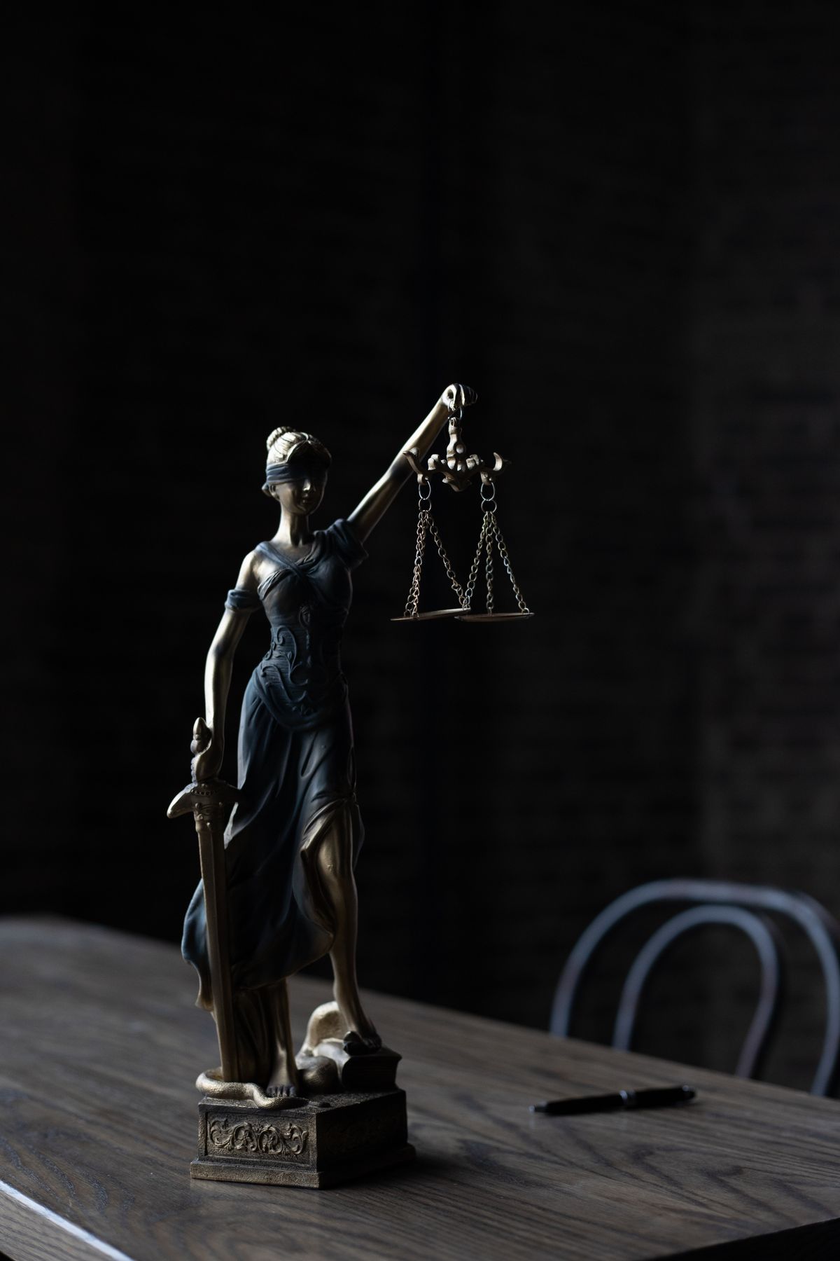 Lady Justice statue on a dark desk