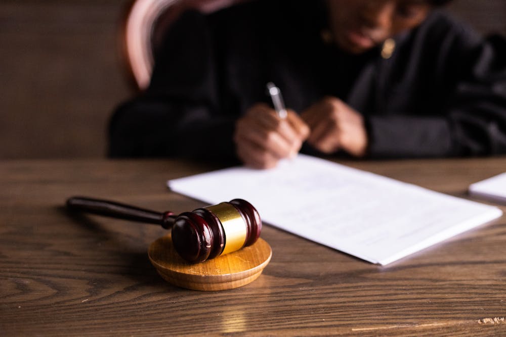 A judge writing on white paper. | Photo: Pexels