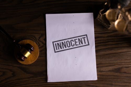 Free Close-Up View of a Text on a Paper beside a Gavel Stock Photo