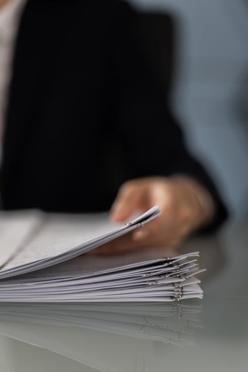 Close-Up Shot of a Person Holding Paperwork 