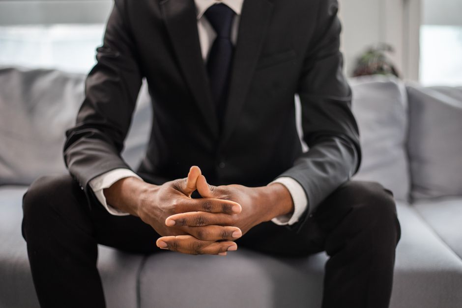 Close-up of a businessman confidently seated in a stylish modern suit indoors.