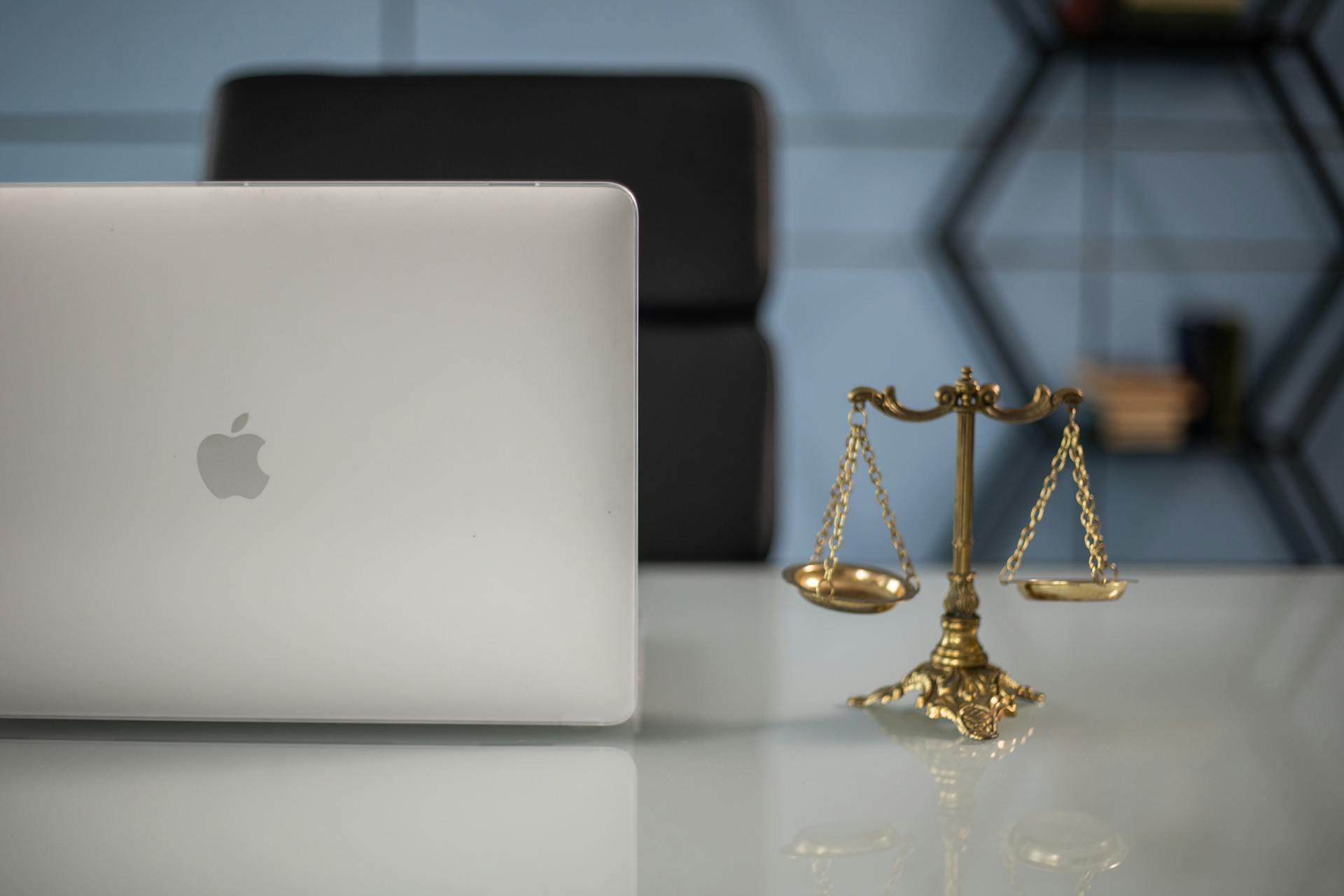 Elegant balance of technology and justice scales on an office desk.