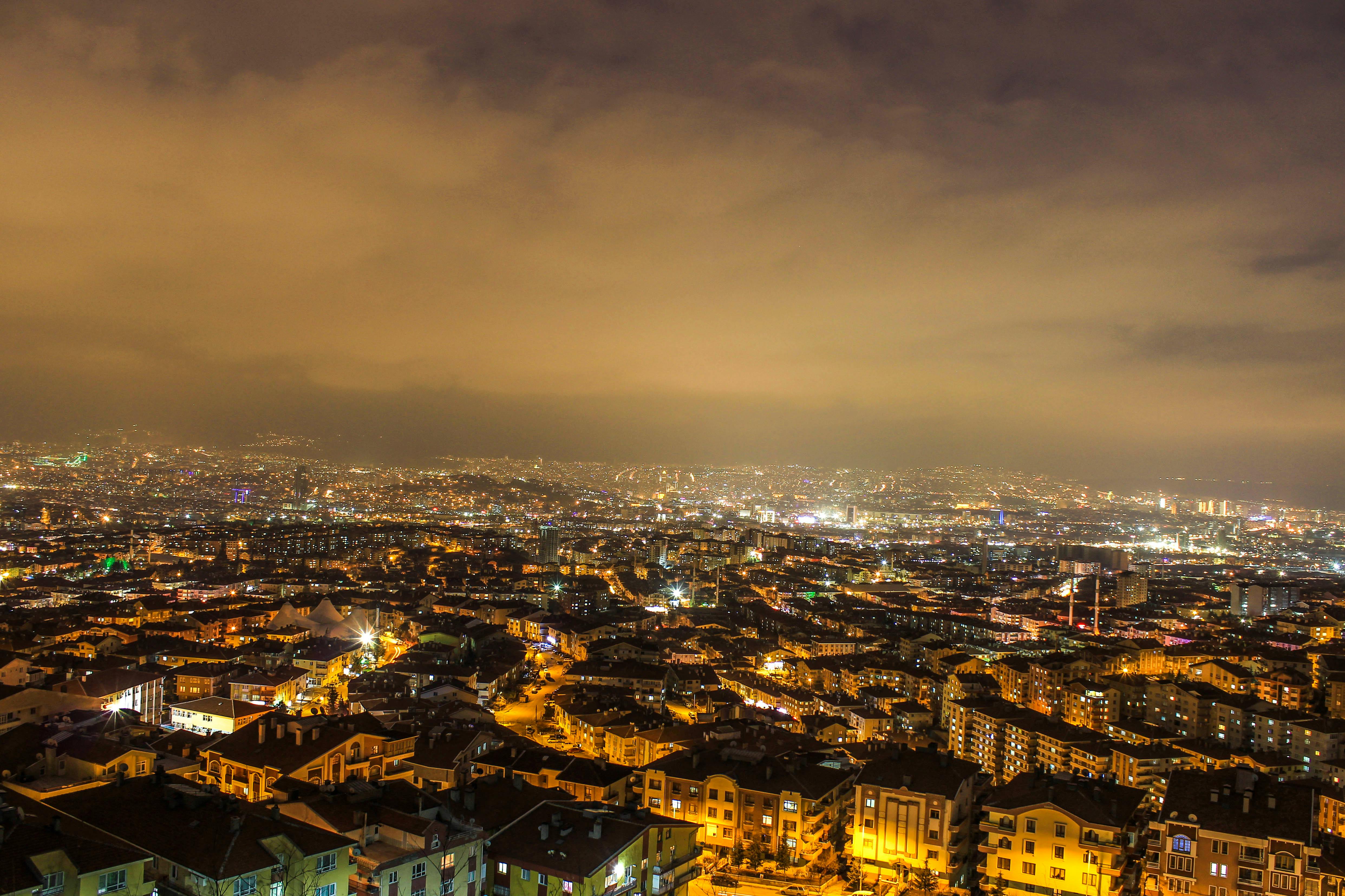 在多云的夜空下，明亮的城市天际线展现出令人惊叹的全景城市景观
