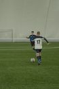 Man in Blue and White Soccer Jersey Kicking Soccer Ball on Green Field