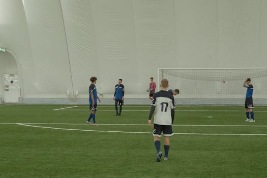 Indoor soccer game with players focusing on strategy and movement.