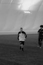 Grayscale of Men Running on a Soccer Field
