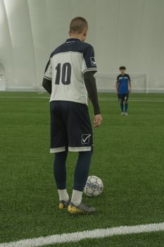 Soccer player in number 10 jersey prepares to take a free kick on an indoor field.