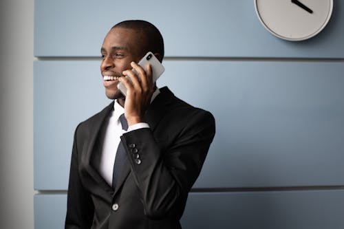 Free Man in Black Suit Holding White Smartphone Stock Photo