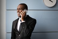 Man in Black Suit Holding White Smartphone