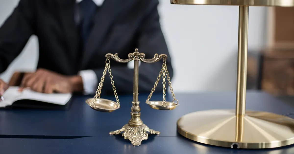 Golden scales of justice on a dark desk in a legal office, representing motor accident compensation