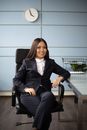 A Woman in a Suit Sitting on an Office Chair