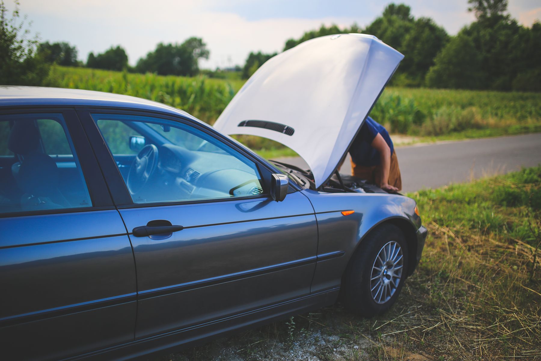 Driver checking the engine of a car stopped on the roadside