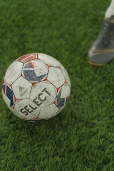 A close-up of a soccer ball on a lush green field, perfect for sports enthusiasts.