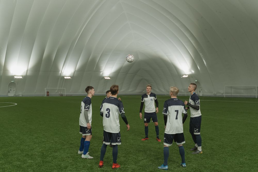 Young team players training together in coordinated uniforms at an indoor sports facility