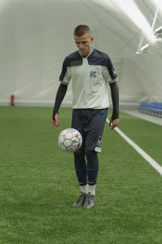 Focused young soccer player practicing ball control indoors. Perfect for sports training themes.