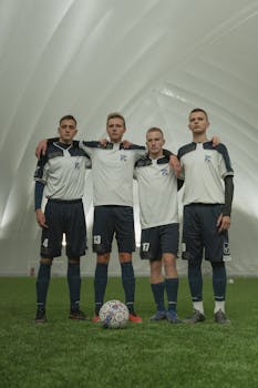 Young male soccer players posing indoors in a dome, showcasing uniform and teamwork.