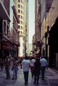Crowded street scene in downtown São Paulo, showcasing urban life and architecture.