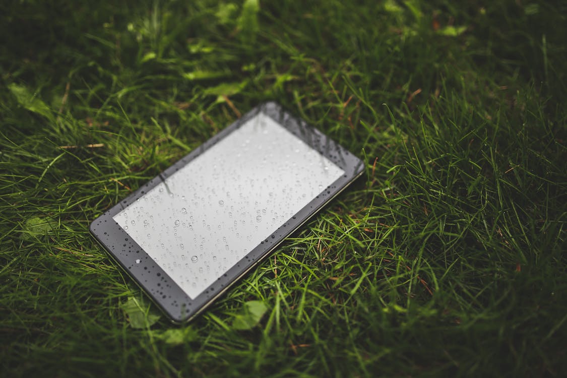 Ücretsiz akıllı telefon, çim, çim alan içeren Ücretsiz stok fotoğraf Stok Fotoğraflar