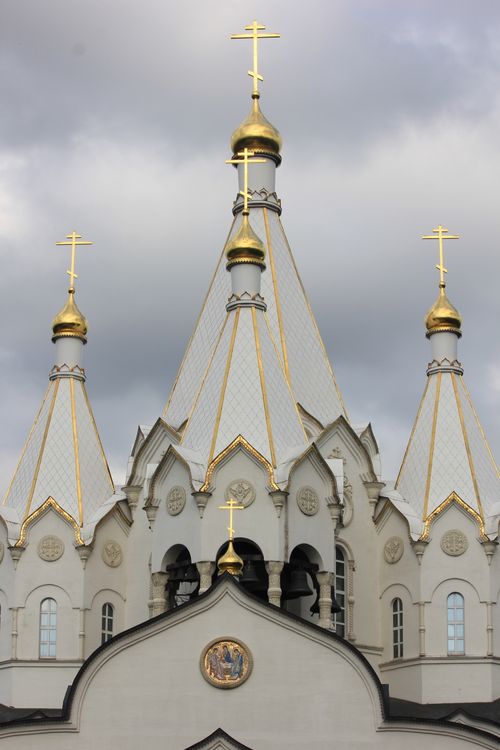 Free Vertical shot of an ornate orthodox church with golden domes and crosses under a cloudy sky. Stock Photo