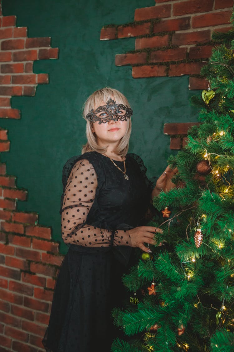 Woman In Carnival Mask Near Christmas Tree