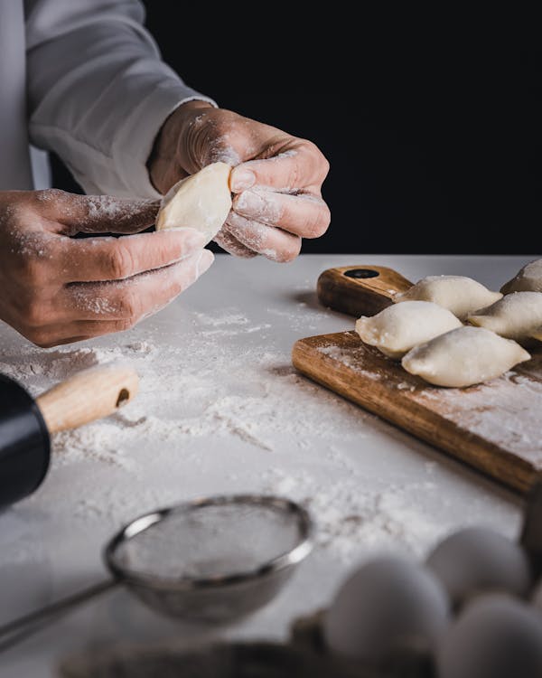 Person Holding Brown Wooden Rolling Pin