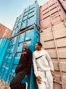 Men in Jogger Ternos Leaning on Blue Cargo Container