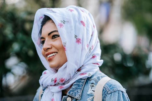 Free Positive young Muslim woman in hijab walking in park Stock Photo