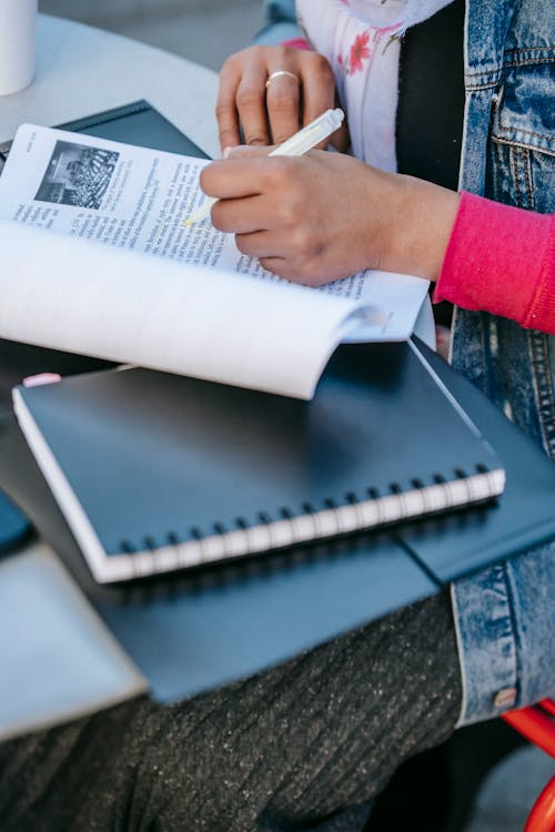 Student sitting at table and studying text in daytime