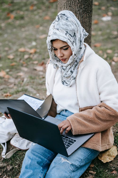 Woman in White Hijab Using Black Laptop 