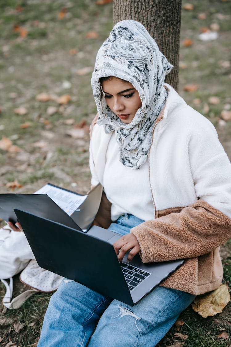 Woman In White Hijab Using Black Laptop 