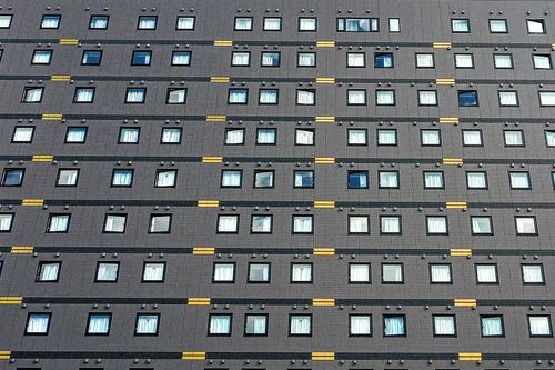 Free From below of huge apartment house with small square windows and modern facade Stock Photo
